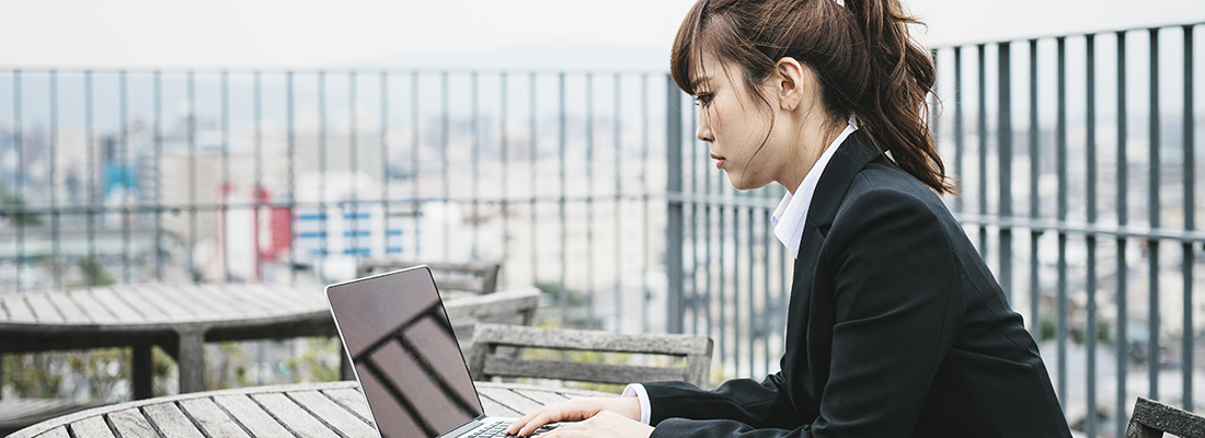 京都の屋外でノートパソコンを使って仕事をする女性